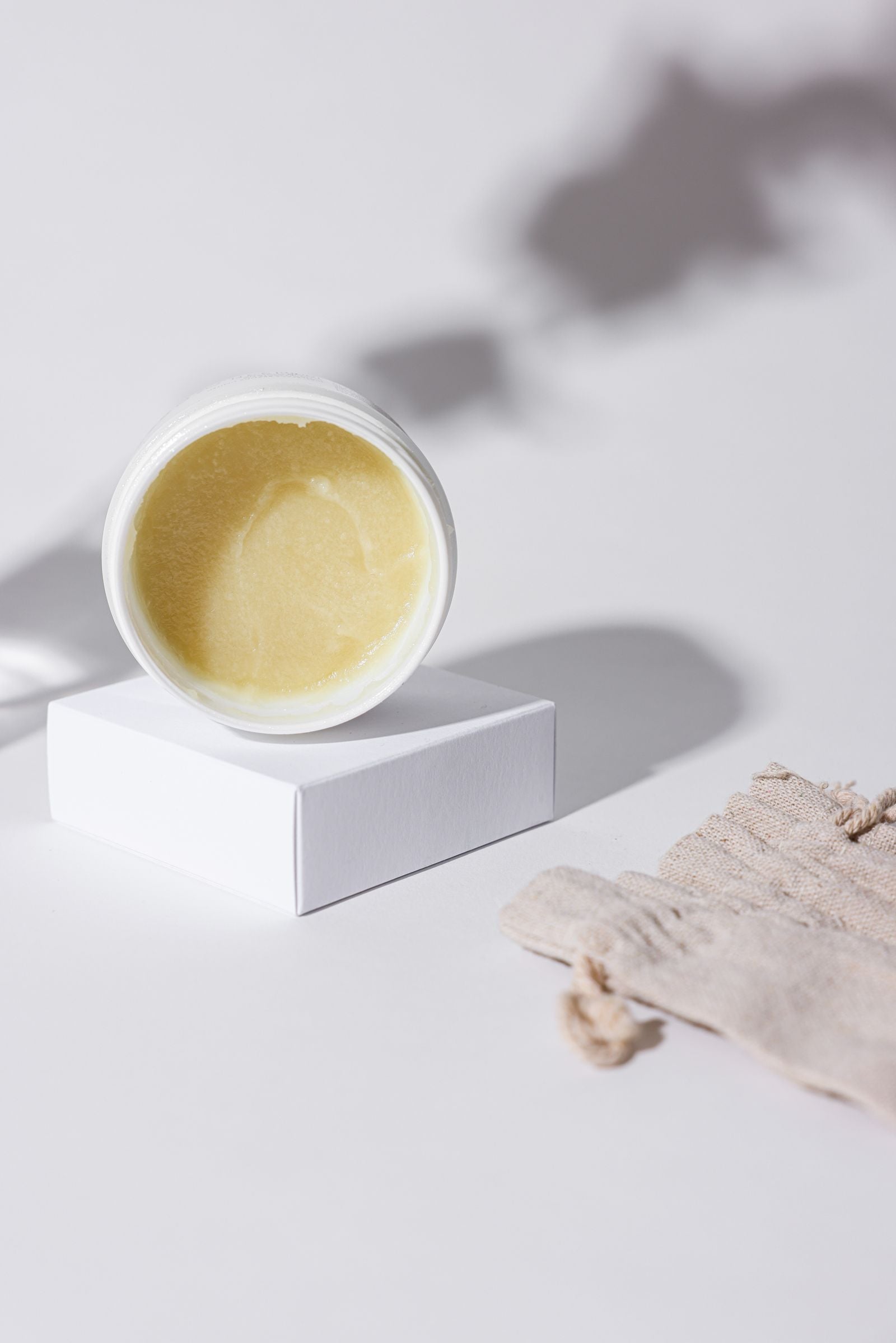 Pot ouvert, texture de la crème, ombre de feuillage au soleil